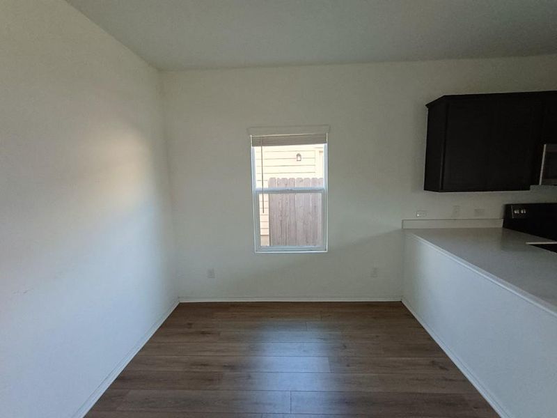 Unfurnished dining area with dark wood-type flooring and baseboards Unfurnished dining area with dark wood-type flooring and baseboards
