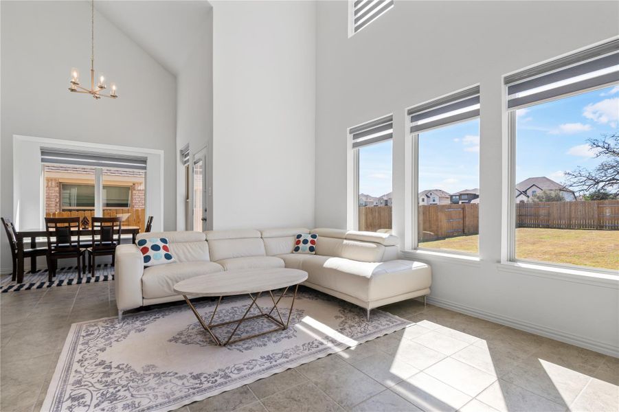 A luminous living space features towering ceilings and generous windows overlooking a private yard. A luminous living space features towering ceilings and generous windows overlooking a private yard.