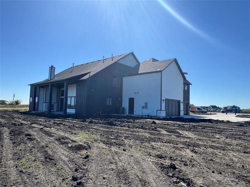 Back of house featuring a garage, a chimney, and a patio