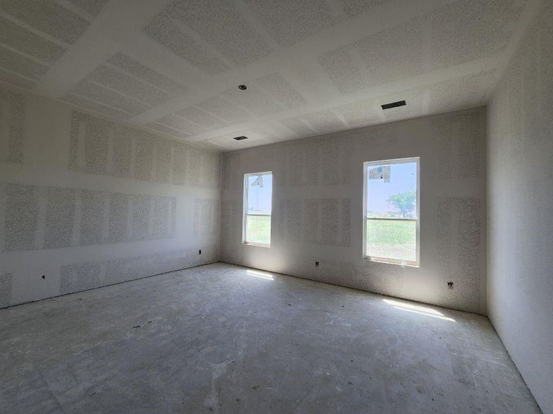 Room featuring two windows, drywall walls, a smooth ceiling, and an exposed concrete floor