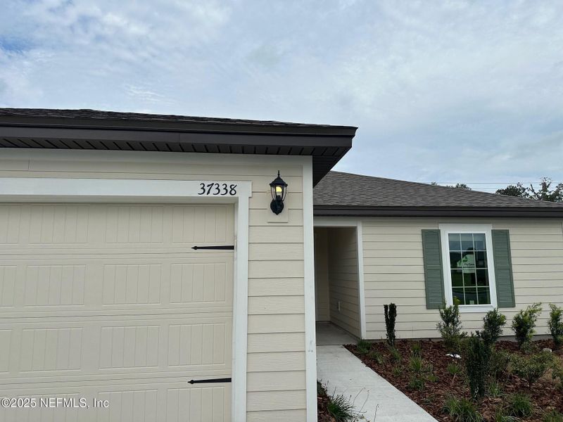 Front exterior of a new home in Whisper Ridge, Hilliard, FL, highlighting curb appeal (Image 2). Front exterior of a new home in Whisper Ridge, Hilliard, FL, highlighting curb appeal (Image 2).