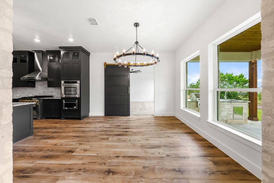 Hardwood floors stretch across this open living space, offering an airy feel with views to the outdoor kitchen.
