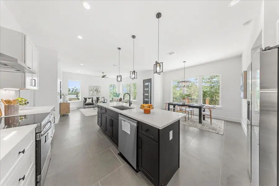 Kitchen featuring stainless steel appliances, dark cabinetry, healthy amount of natural light, recessed lighting, and open floor plan Kitchen featuring stainless steel appliances, dark cabinetry, healthy amount of natural light, recessed lighting, and open floor plan
