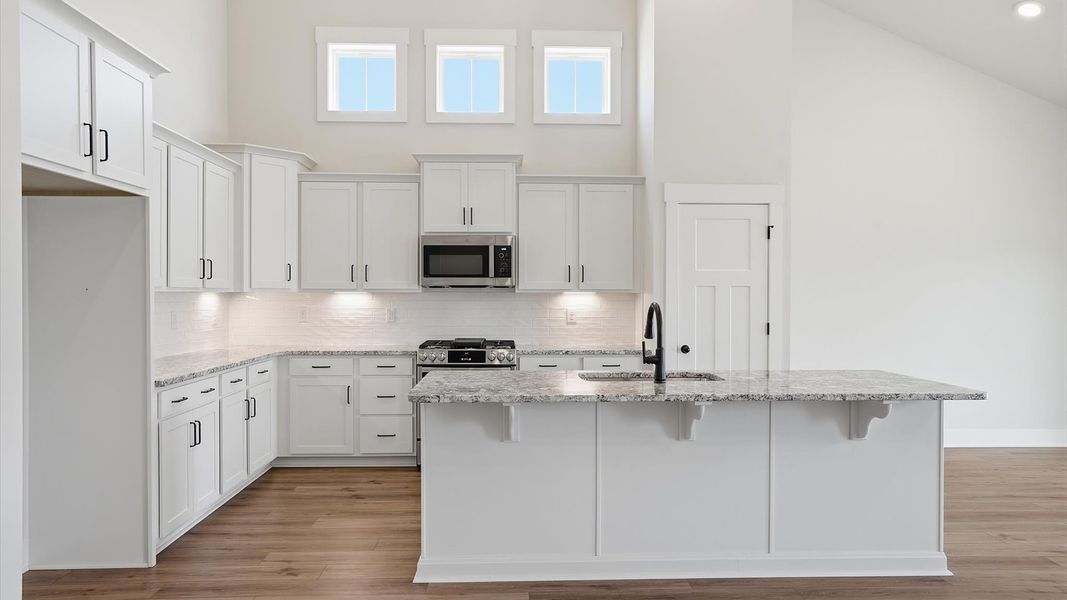 Tasteful kitchen with a streamlined island and modern finishes in a first-class DRB Homes design Tasteful kitchen with a streamlined island and modern finishes in a first-class DRB Homes design