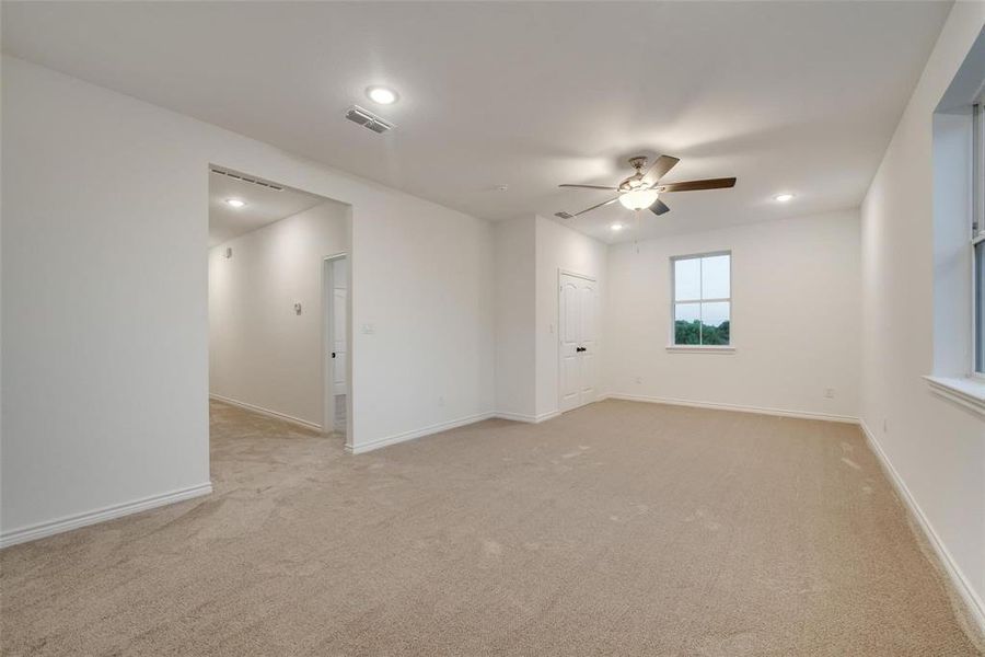 Empty room featuring light colored carpet, recessed lighting, and ceiling fan