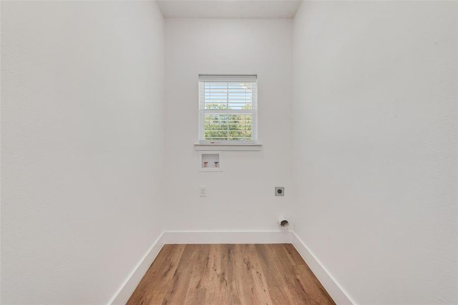 Laundry area featuring light wood-style flooring, washer hookup, and electric dryer hookup Laundry area featuring light wood-style flooring, washer hookup, and electric dryer hookup