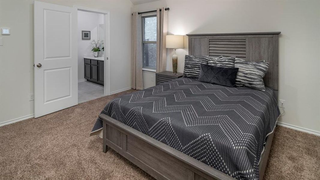 Carpeted bedroom with baseboards and ensuite bathroom