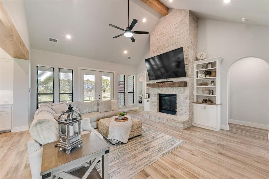 Open concept with a gas log fireplace and built-in shelves.