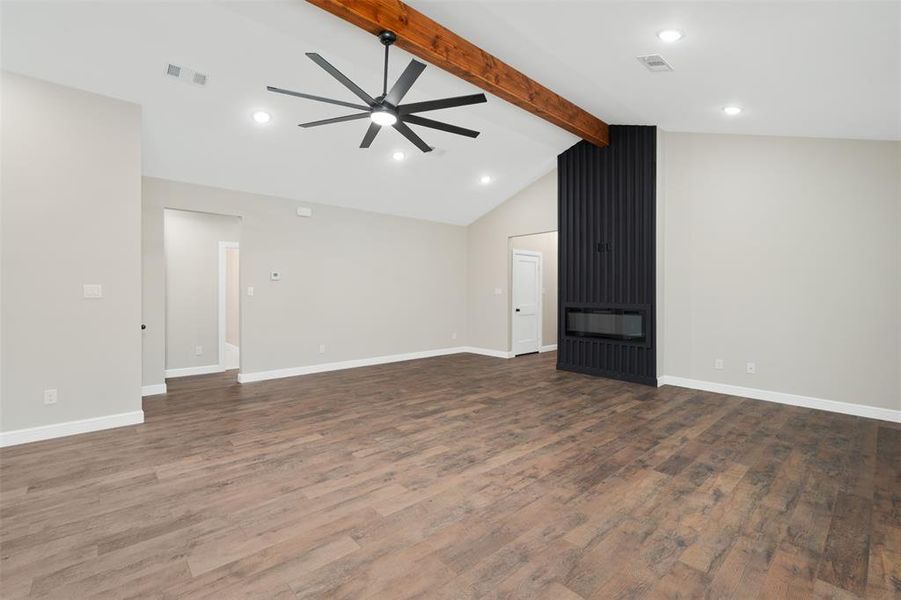 Unfurnished living room with wood finished floors, a large fireplace, ceiling fan, and recessed lighting