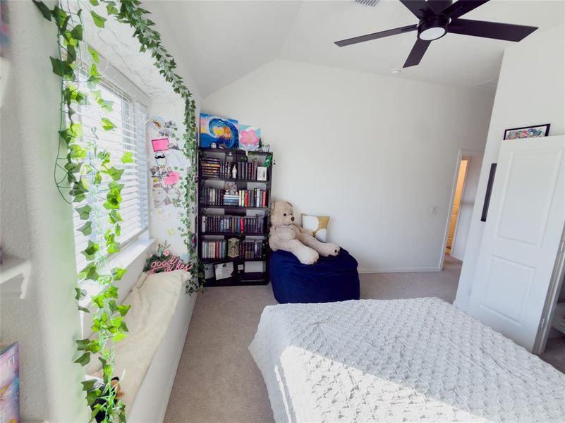 Bedroom featuring light carpet, vaulted ceiling, and a ceiling fan