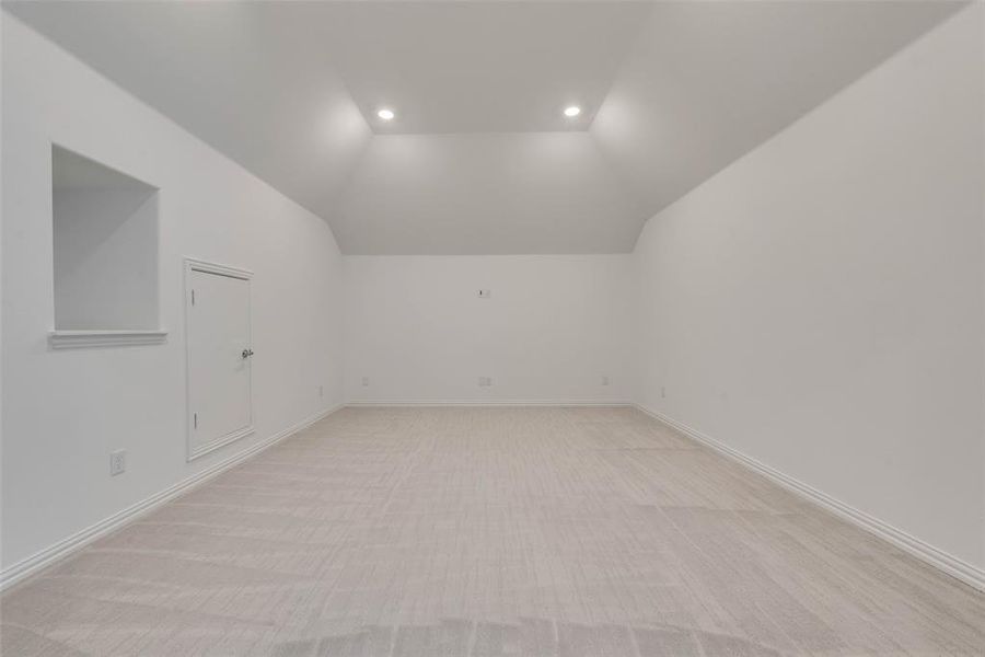 Bonus room featuring lofted ceiling and light colored carpet