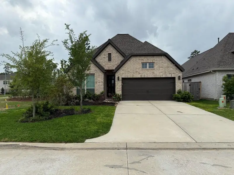 Front exterior of a new home in Grand Central Park 45', Conroe, TX, highlighting curb appeal (Image 1).