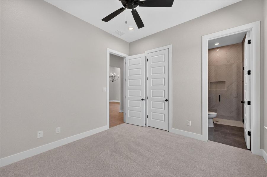 An inviting bedroom features plush carpeting and convenient direct access to a private bathroom.