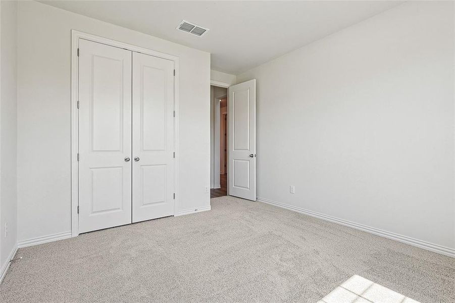 Unfurnished bedroom featuring light colored carpet and a closet