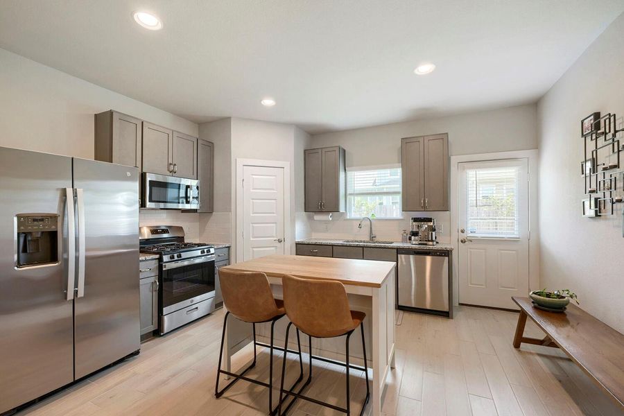 Culinary delights await in this modern kitchen with stainless steel appliances and an inviting island for casual dining. Culinary delights await in this modern kitchen with stainless steel appliances and an inviting island for casual dining.