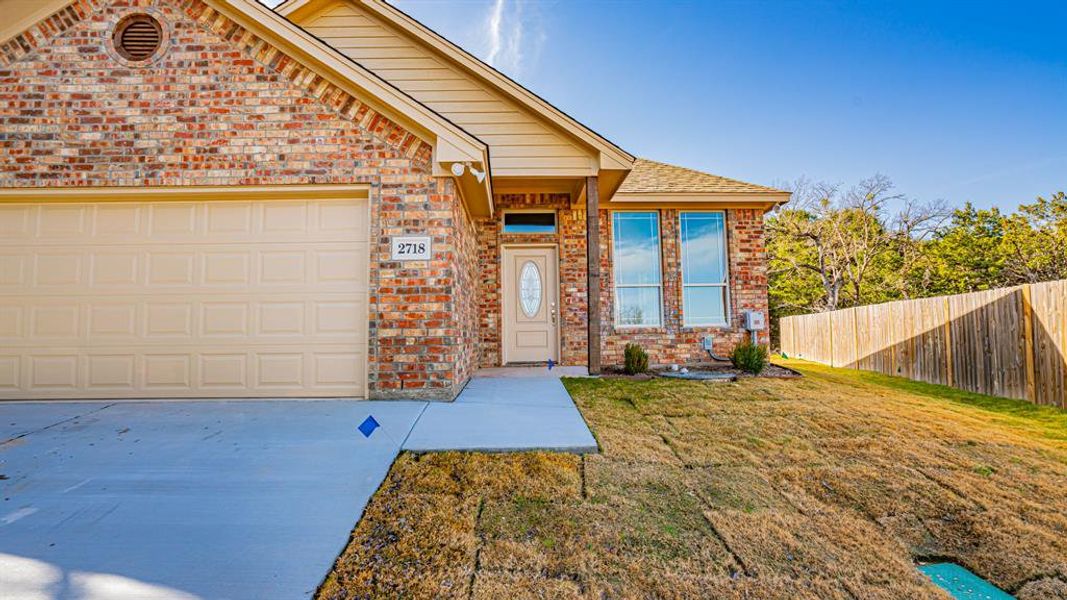 View of front of house with brick siding, driveway, and an attached garage
