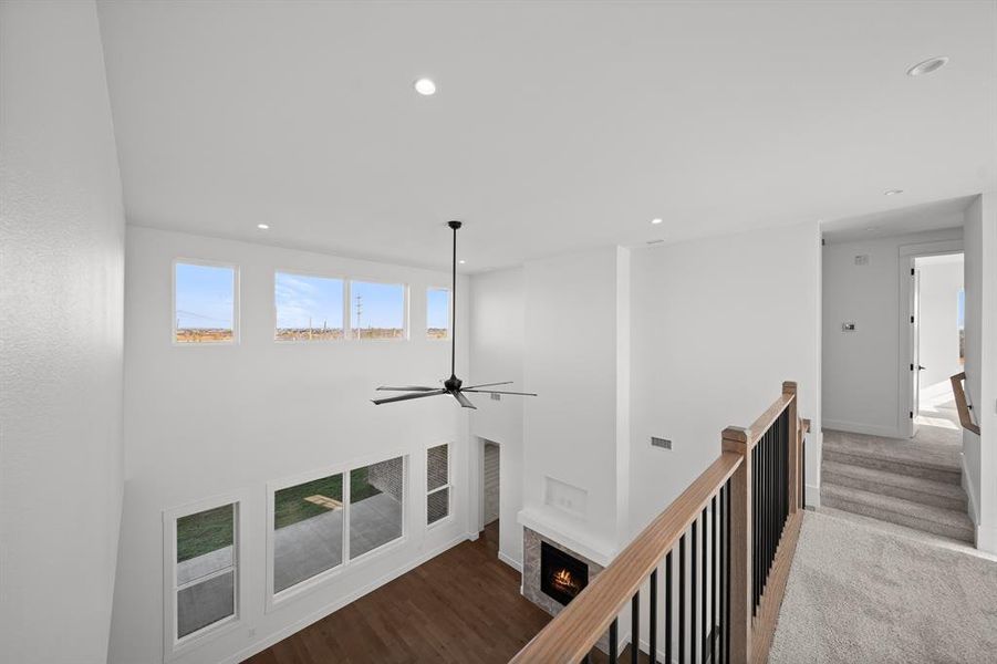 Hallway featuring an upstairs landing, recessed lighting, and a towering ceiling