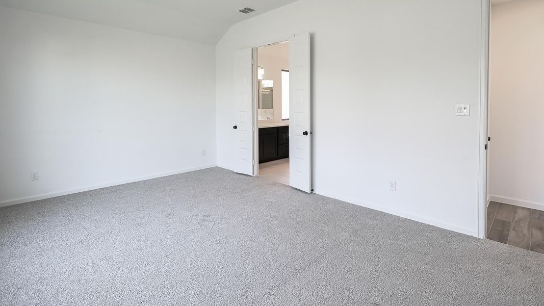 Unfurnished bedroom featuring light carpet, ensuite bathroom, and lofted ceiling Unfurnished bedroom featuring light carpet, ensuite bathroom, and lofted ceiling
