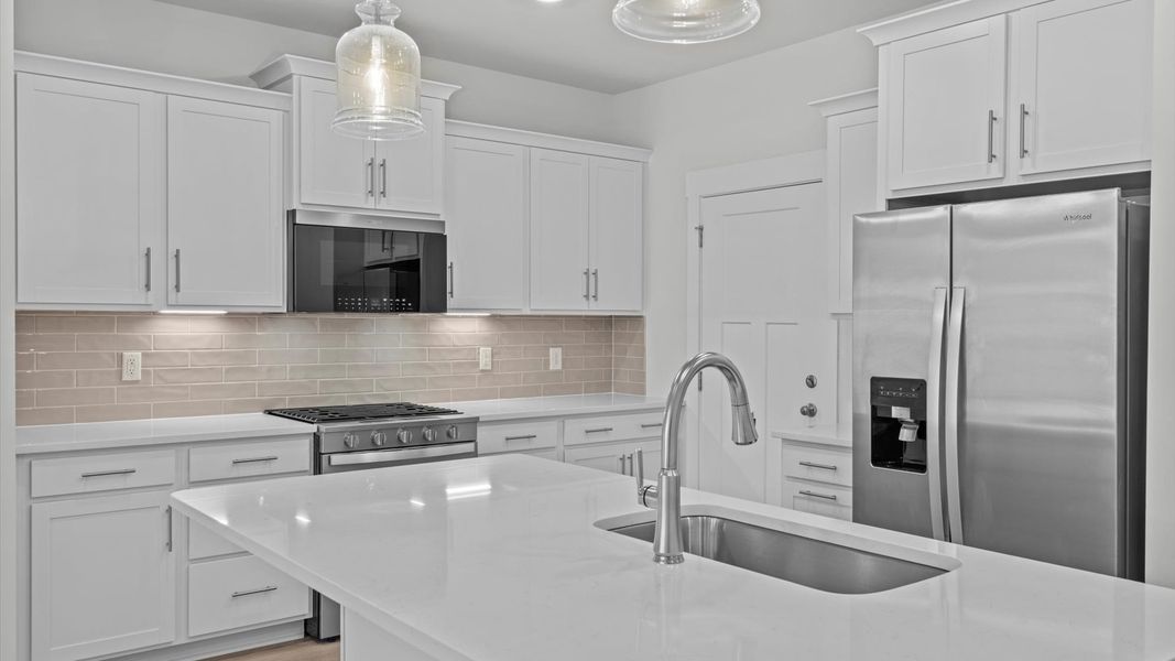 Accomplished kitchen design featuring pendant lighting above a statement island for both prep and gathering Accomplished kitchen design featuring pendant lighting above a statement island for both prep and gathering