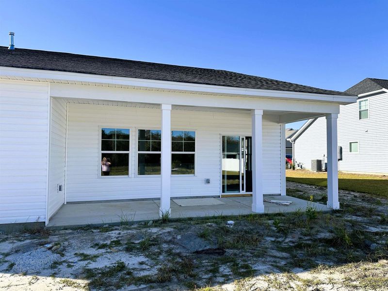 Back of property featuring roof with shingles and covered porch