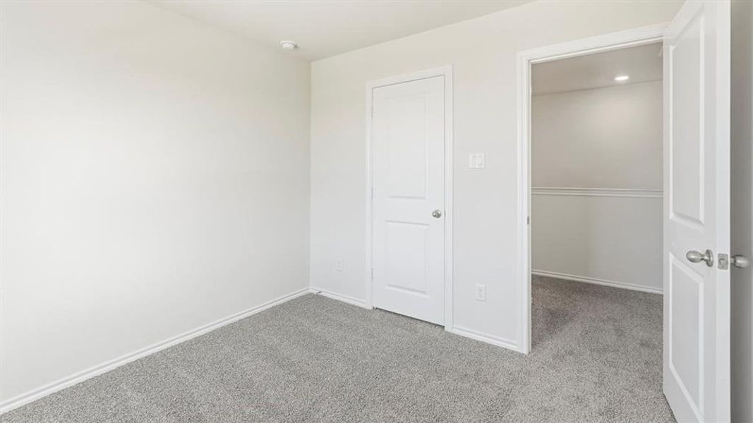 Unfurnished bedroom featuring carpet floors and baseboards