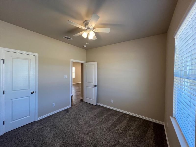 bedroom 3, with ceiling fan and dark carpet