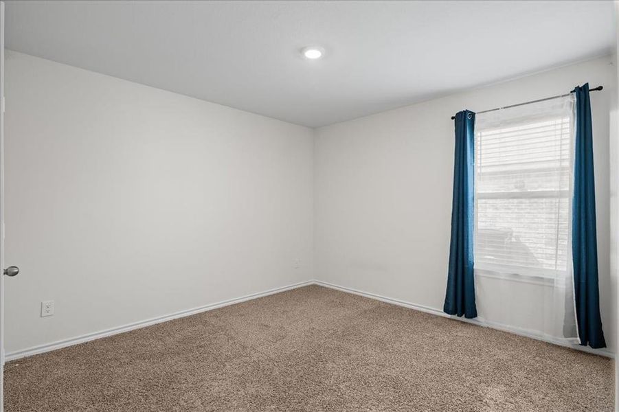 Empty room with carpet flooring and baseboards Empty room with carpet flooring and baseboards