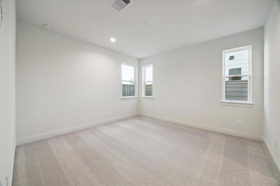 This spacious first-floor bedroom offers ample natural light through multiple windows, creating a bright and welcoming atmosphere. The neutral carpeting and clean design provide a versatile space suitable for a guest room, home office, or personal retreat. With a functional layout, this room offers comfort and flexibility for a variety of uses.