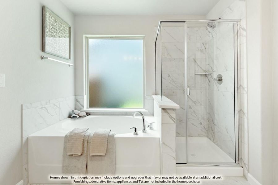 Bathroom with soaking tub, glass-enclosed shower, and marble tile walls next to a frosted window