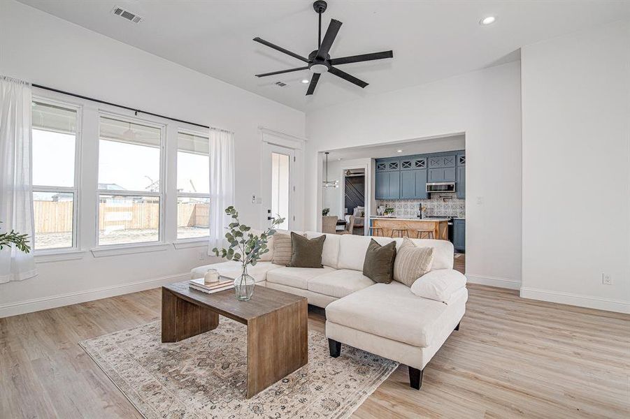 Living room featuring light wood-style floors, recessed lighting, and ceiling fan