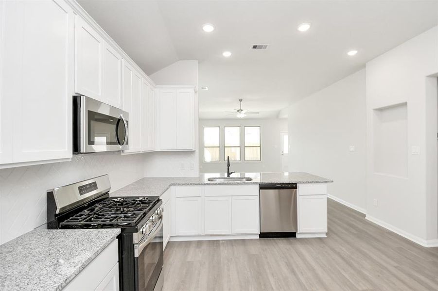 Discover another perspective of this stunning kitchen, generously appointedwith an abundance of counter space.