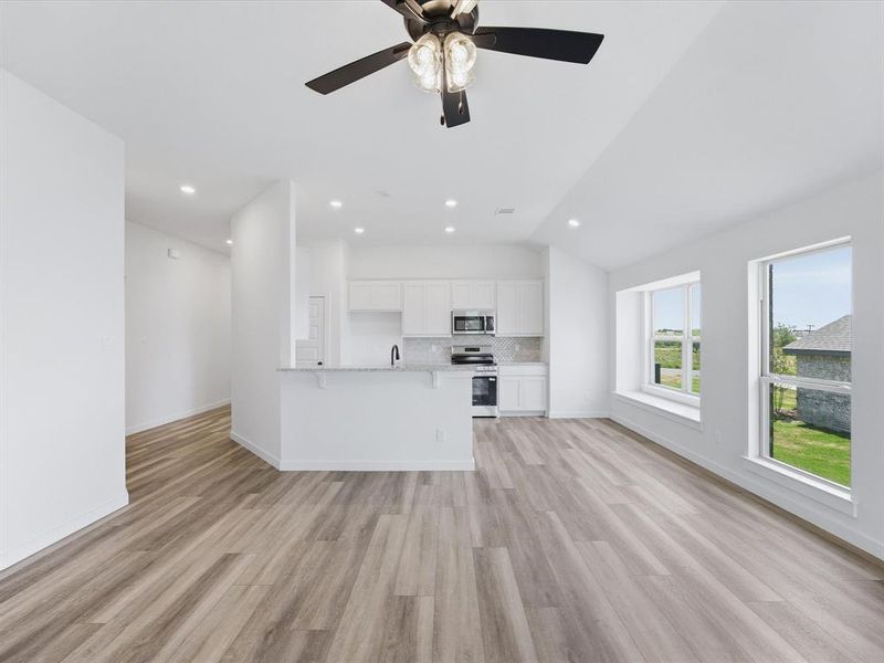 Open-concept living space featuring wood-finish flooring, recessed lighting, and a ceiling fan Open-concept living space featuring wood-finish flooring, recessed lighting, and a ceiling fan