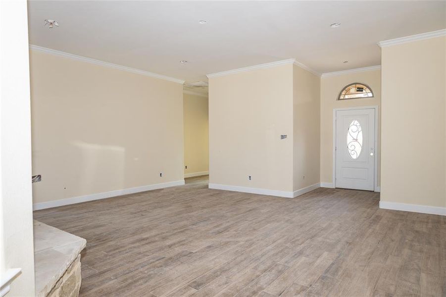 Entrance foyer featuring ornamental molding and light wood-type flooring