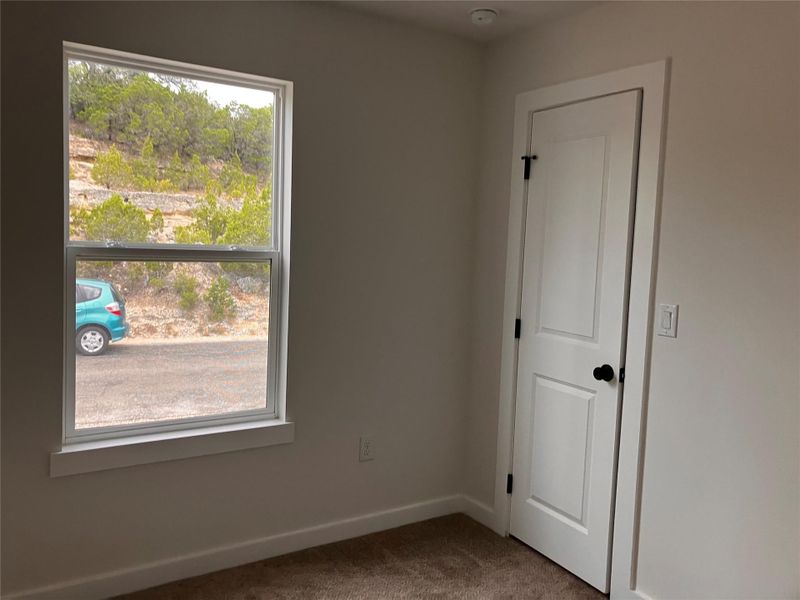 Unfurnished room with baseboards and dark carpet