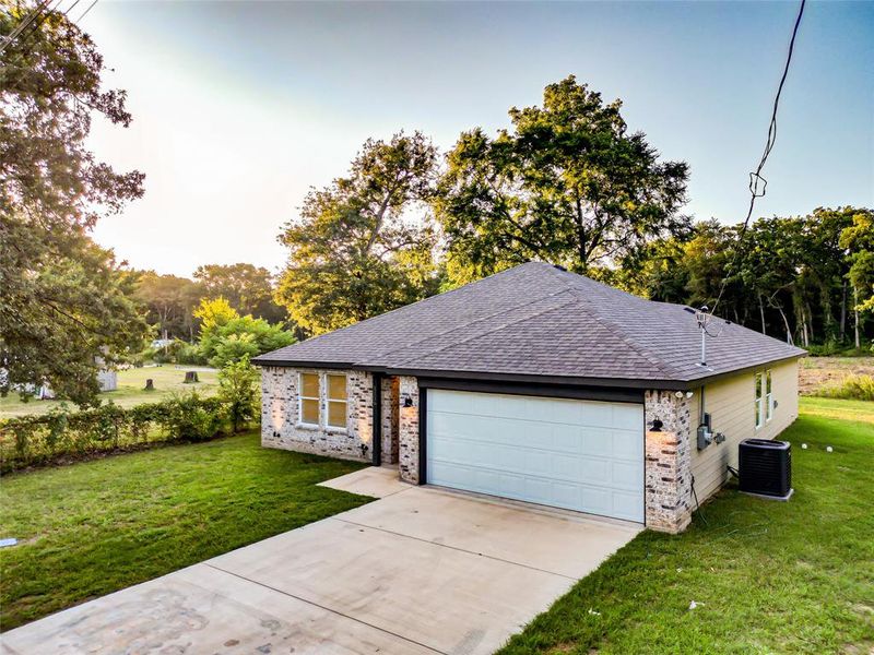 Ranch-style house featuring brick siding, roof with shingles, a front lawn, driveway, and an attached garage Ranch-style house featuring brick siding, roof with shingles, a front lawn, driveway, and an attached garage