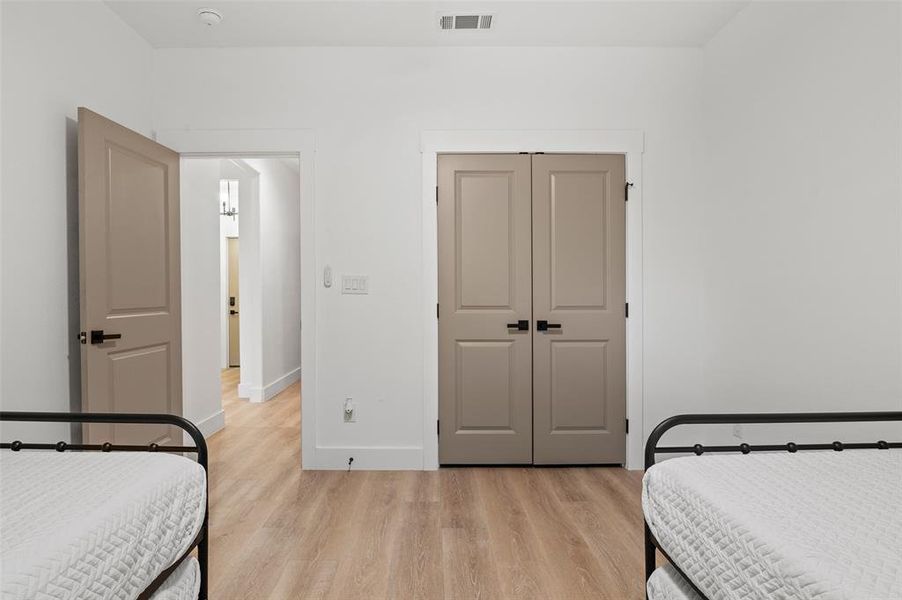 Bedroom with light hardwood / wood-style floors and a closet