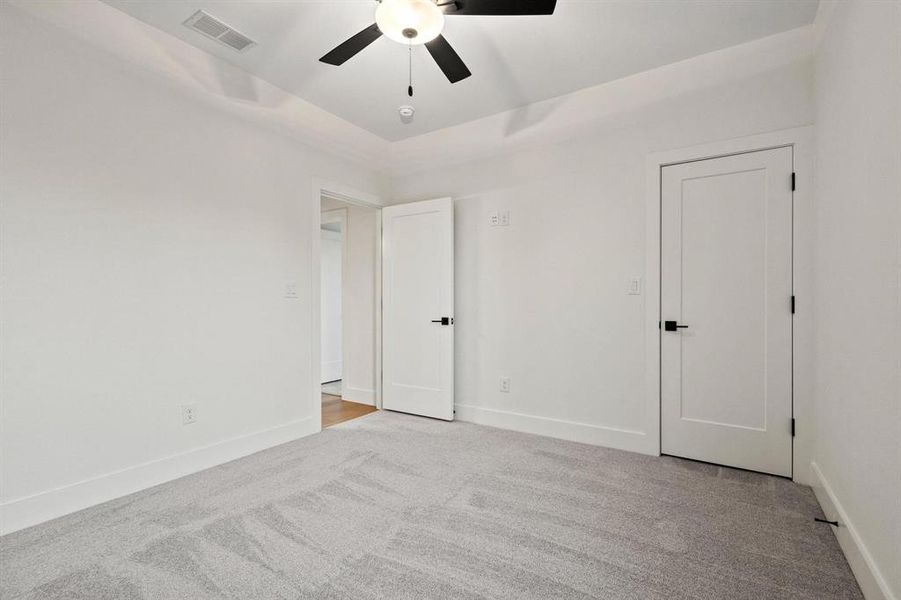 Unfurnished room featuring light carpet and a ceiling fan