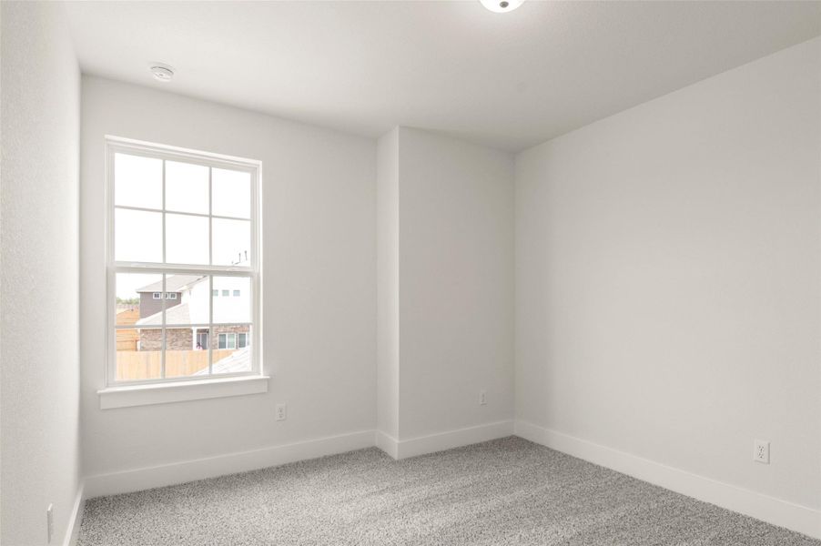 Empty room with a healthy amount of sunlight, baseboards, and carpet flooring