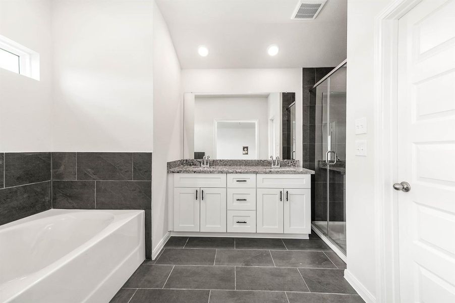 Primary bathroom features a double vanity sink, a glass-enclosed walk-in shower, and soaking tub. Primary bathroom features a double vanity sink, a glass-enclosed walk-in shower, and soaking tub.
