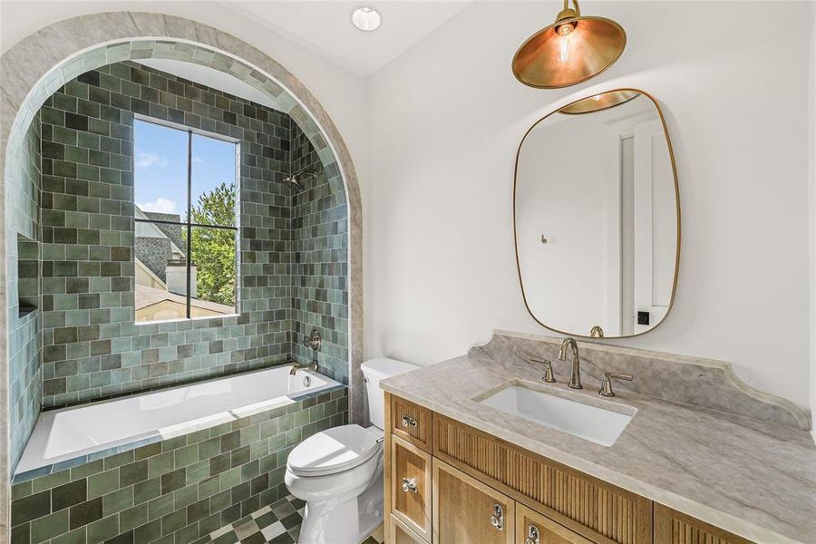 Bathroom featuring a built-in bathtub with a window, green subway tile surround, and a checkered floor pattern