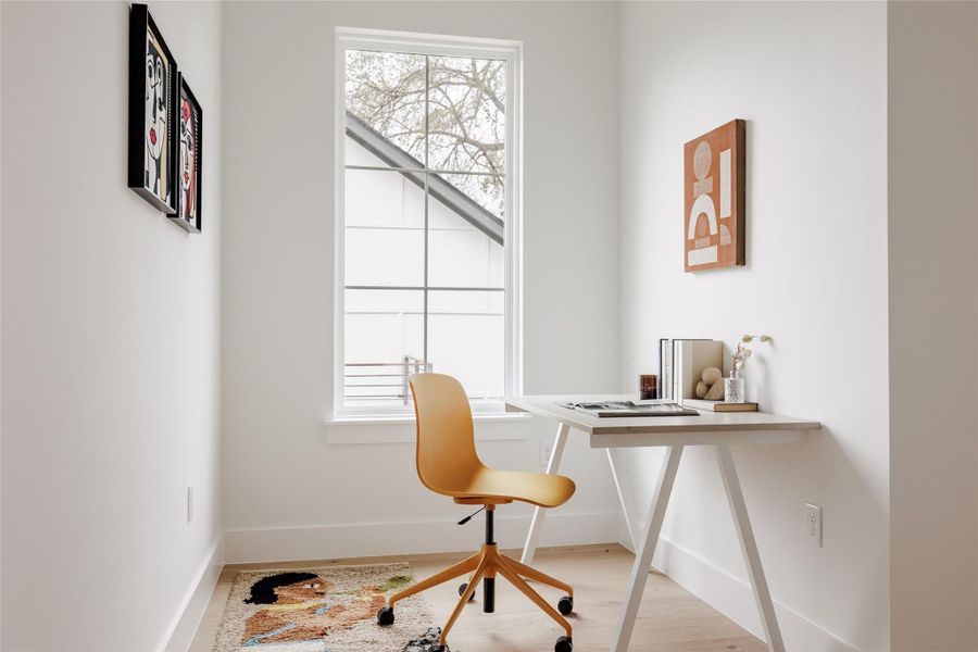 Home office featuring light wood-type flooring and baseboards