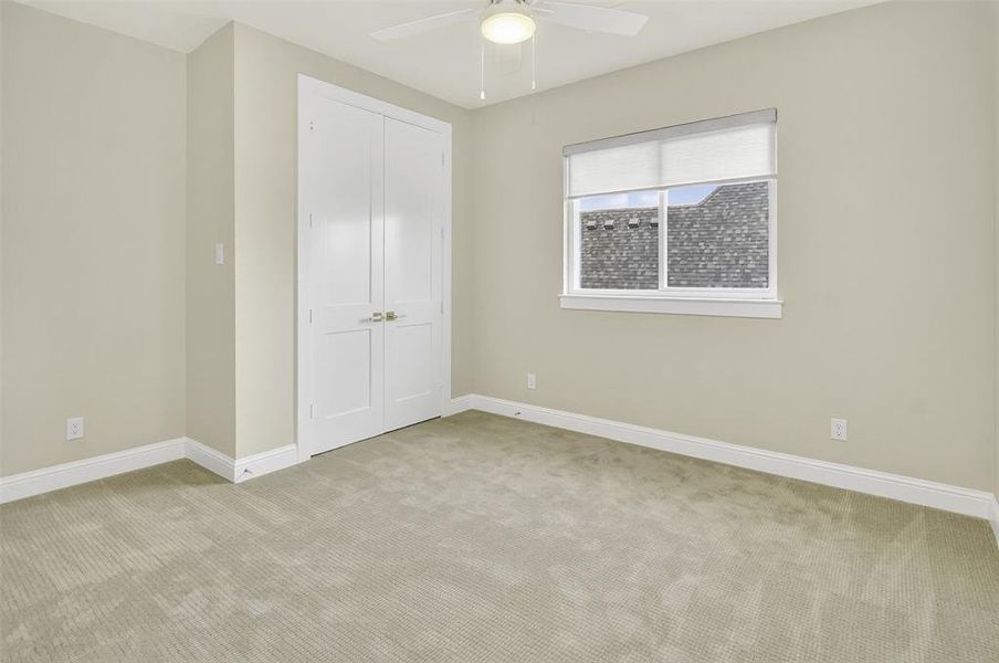 Unfurnished bedroom featuring carpet flooring, a closet, and ceiling fan