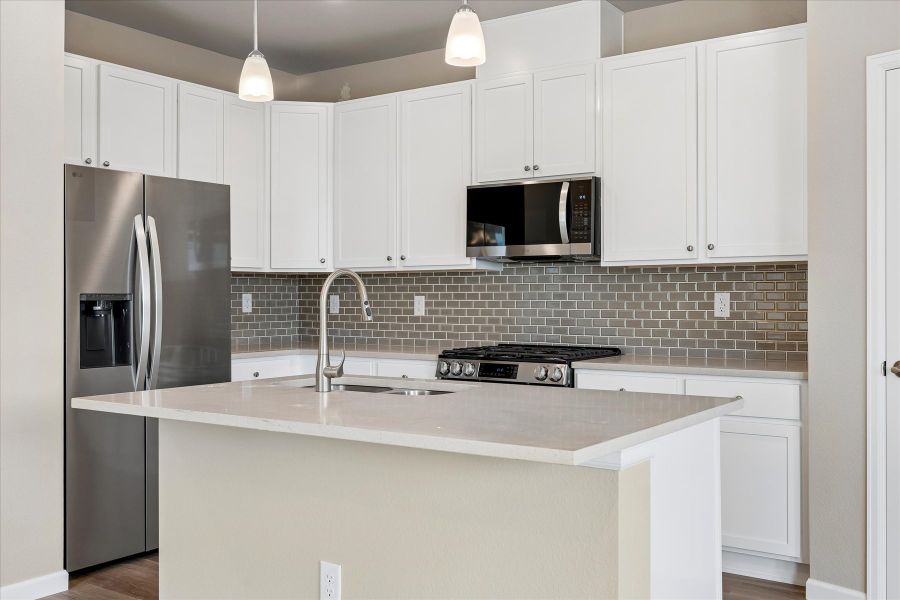 A kitchen with white cabinets.