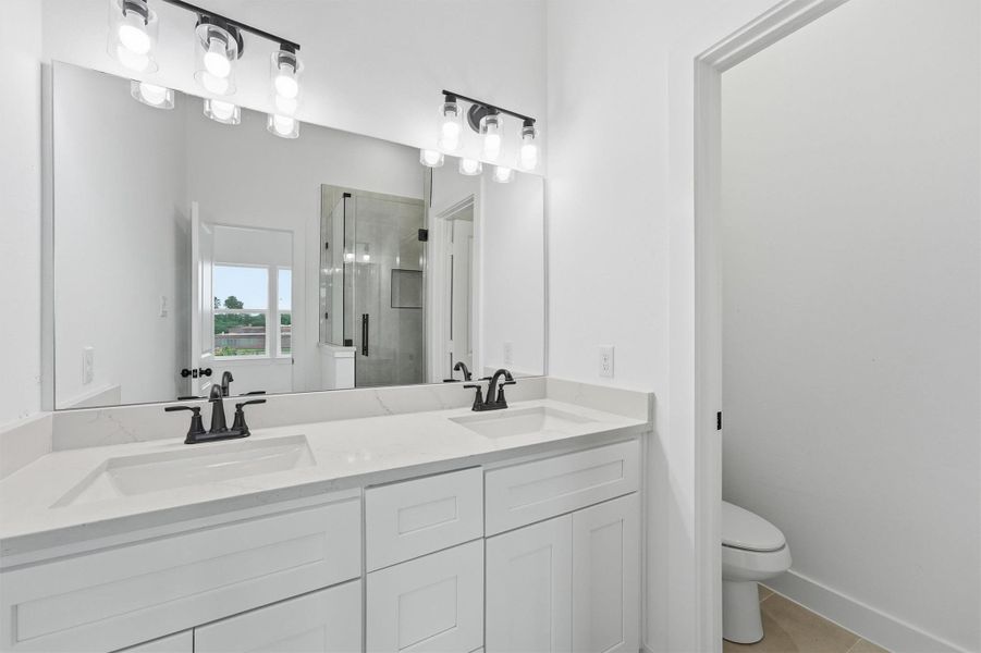 Start and end every day in style. This luxurious primary en-suite with a double-sink quartz vanity, matte black fixtures, designer lighting, and a frameless glass shower elevates your daily routine into something you'll actually look forward to. Start and end every day in style. This luxurious primary en-suite with a double-sink quartz vanity, matte black fixtures, designer lighting, and a frameless glass shower elevates your daily routine into something you'll actually look forward to.