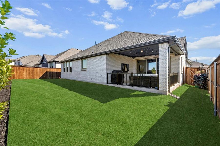Back of house featuring a patio area, a fenced backyard, a shingled roof, and full brick siding