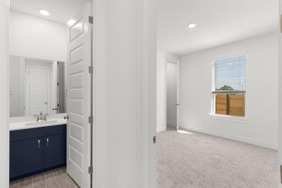 Bathroom featuring vanity, light colored carpet, and recessed lighting