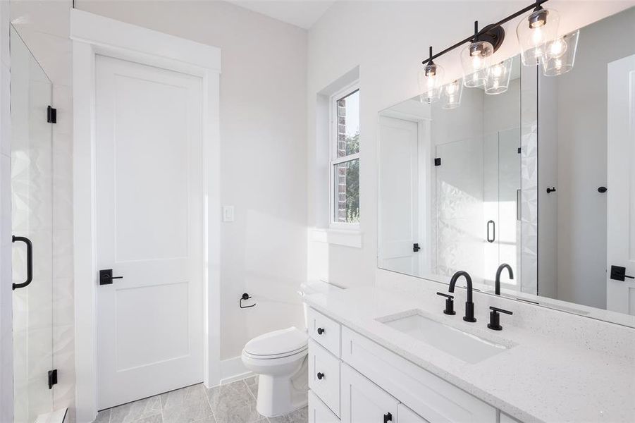 Bathroom with tile patterned flooring, a shower with door, toilet, and vanity