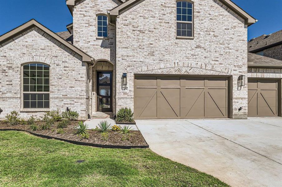 View of front of home featuring a garage and a front lawn