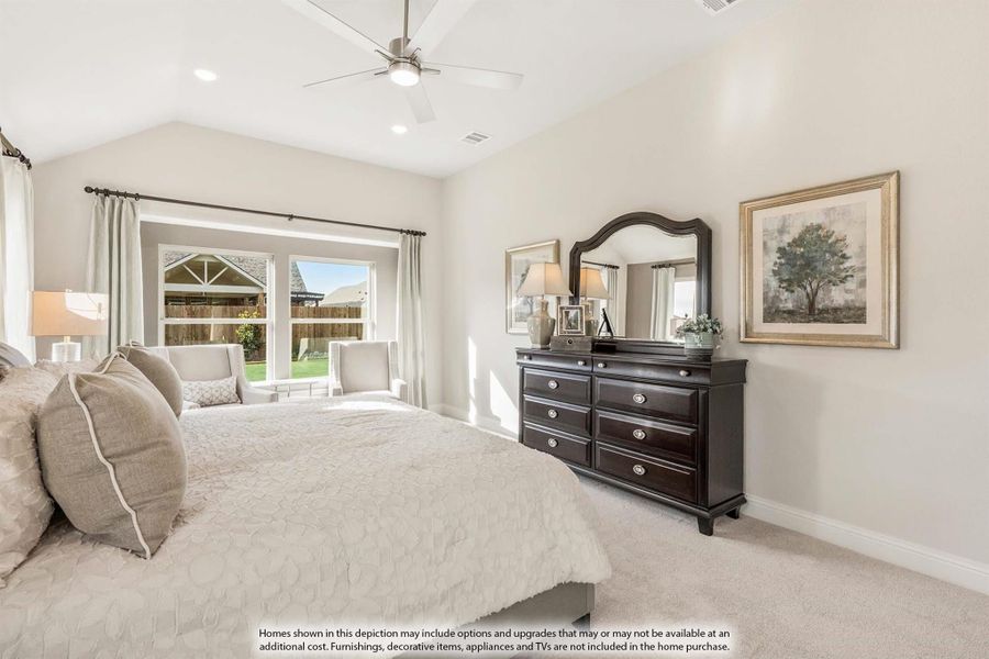 Bedroom with vaulted ceiling, ceiling fan, dark wood dresser, and large window with backyard view