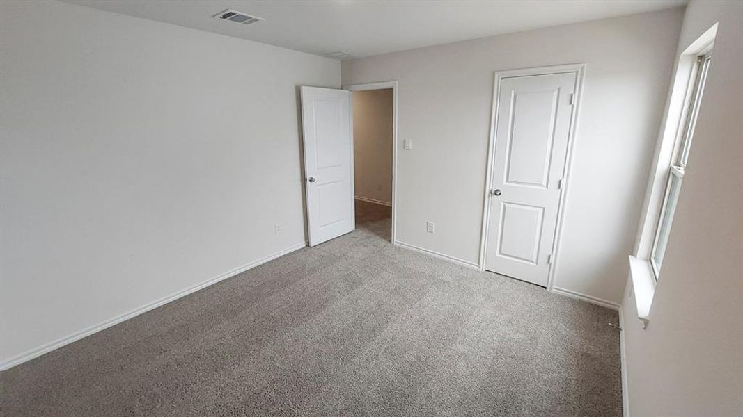 Unfurnished bedroom with carpet flooring and baseboards Unfurnished bedroom with carpet flooring and baseboards